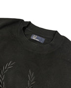 GEGENHALT schwarzer Pullover aus Baumwolle mit Rundhalsausschnitt und Lorbeerkranz-Logo