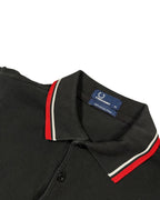 GEGENHALT. Schwarzes Herren Poloshirt aus Baumwolle mit roten und weißen Kontraststreifen an Kragen und Ärmeln.